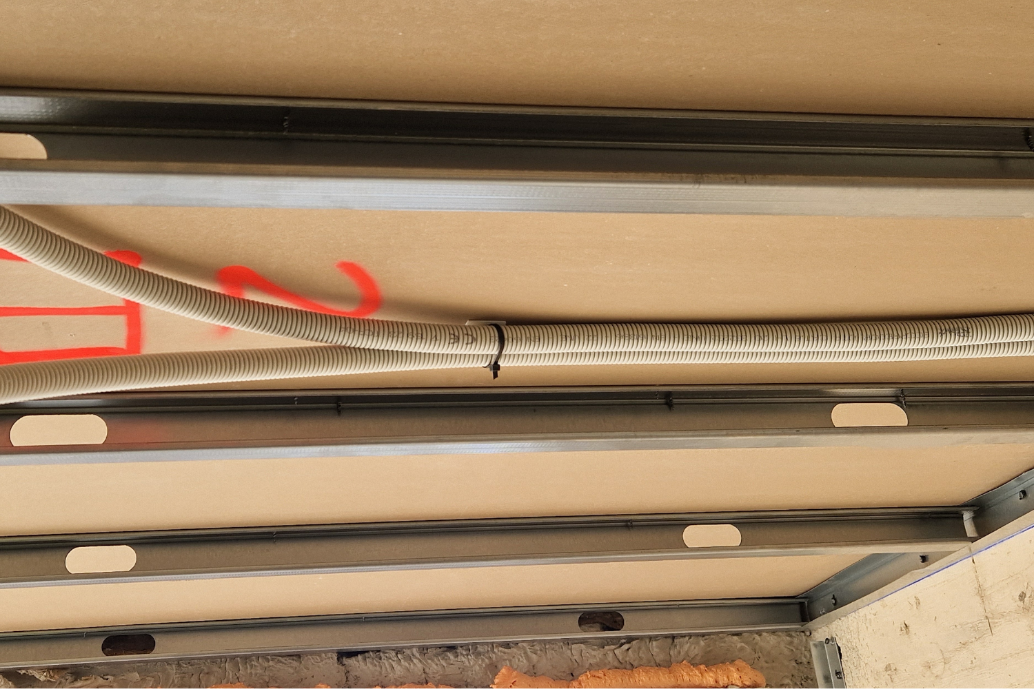 Aplicación de base adhesiva con brida para fijación de tubo corrugado