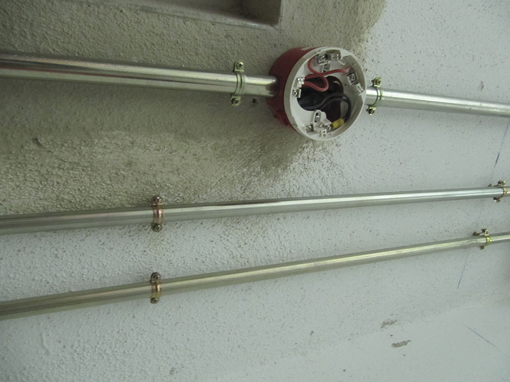 Aplicación de abrazadera metálica M6 L para fijación segura de tubos en instalaciones eléctricas