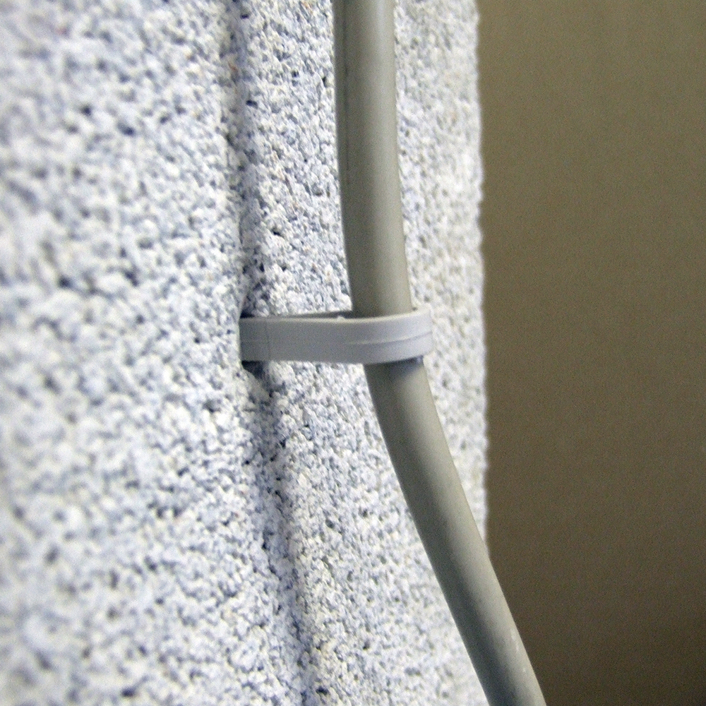 Fijación de cable con clip plástico para organización en pared
