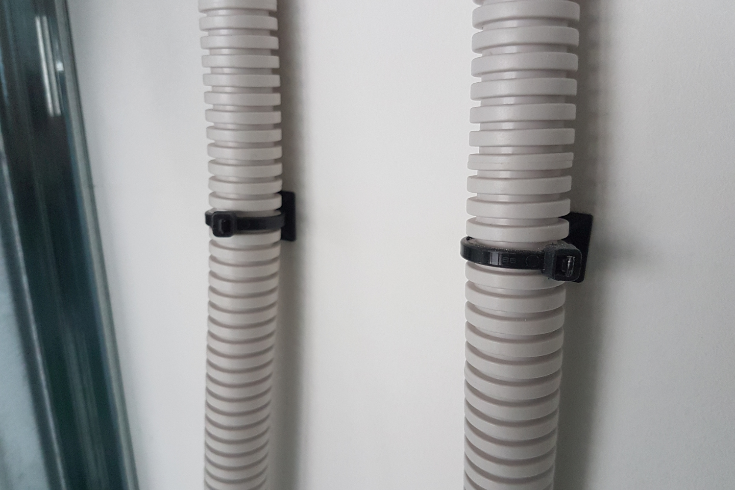 Aplicación de base adhesiva con brida para fijación de tubo corrugado