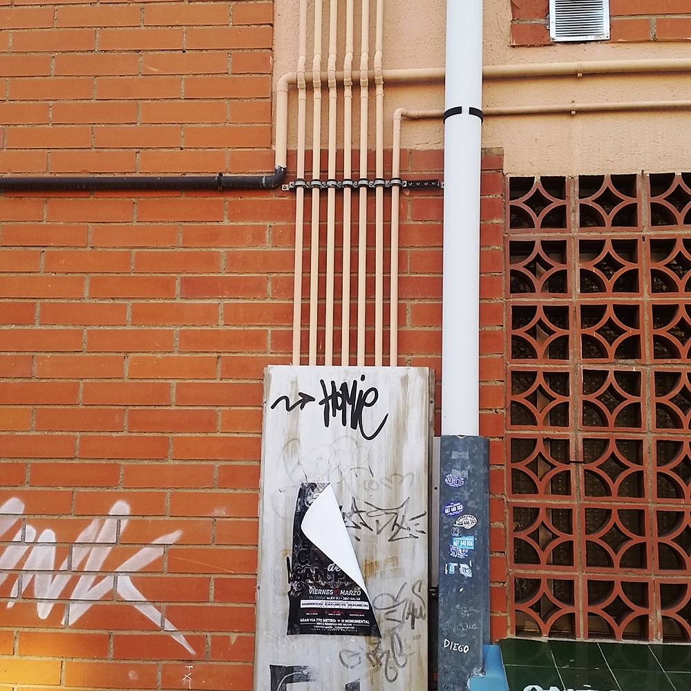 Instalación de tubos con soporte isofónico SMI en fachada de ladrillo