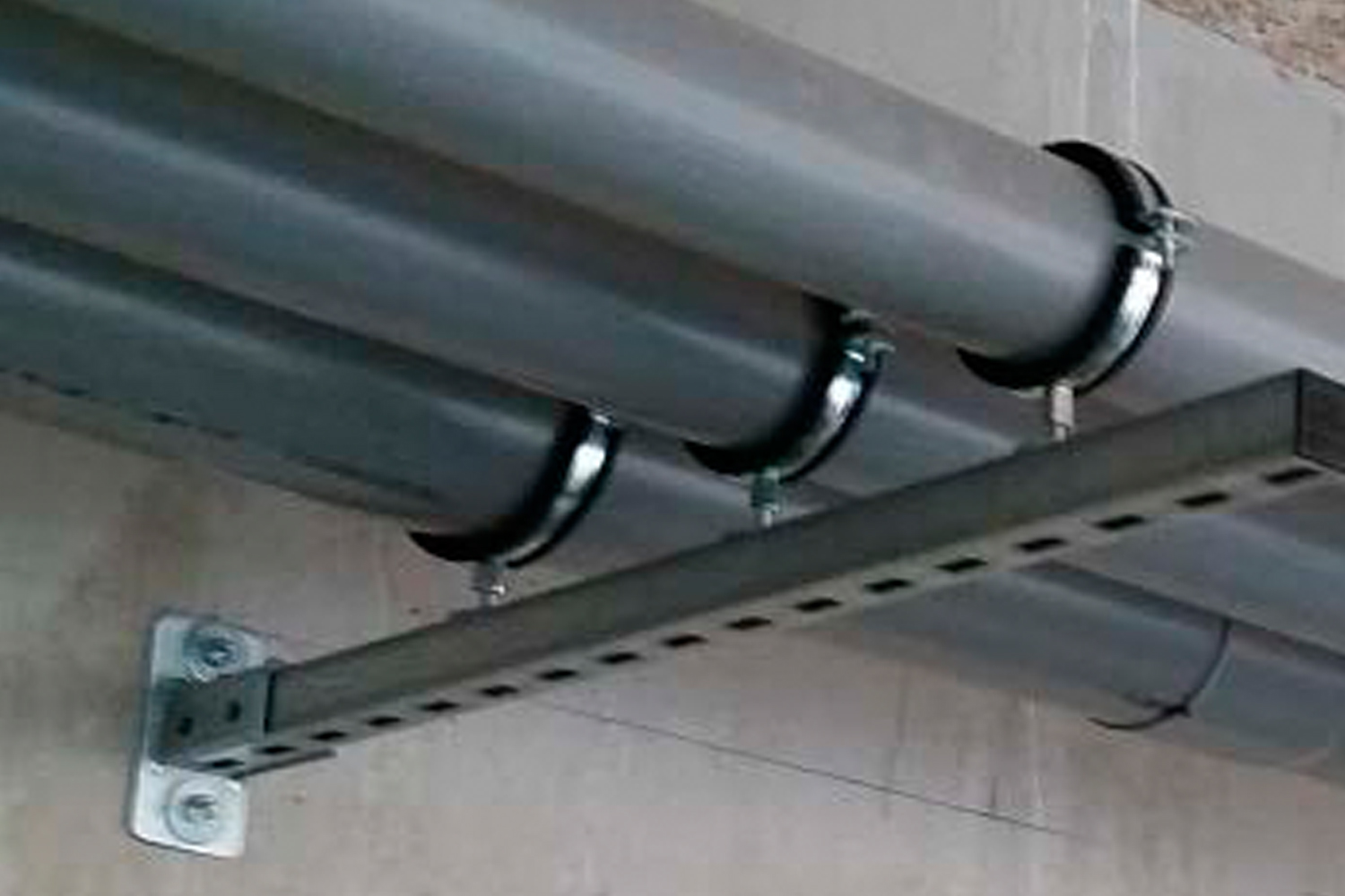 Imagen de aplicación del tornillo para hormigón BTS6: el tornillo para hormigón sujeta una barra de perfil con tubos.
