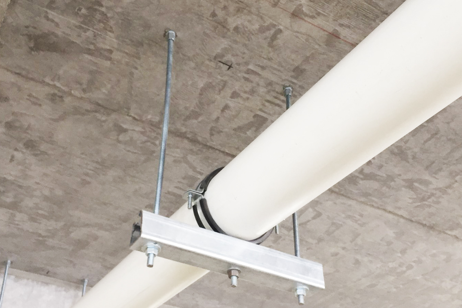 Imagen de aplicación del tornillo para hormigón BTS6 H con rosca interior: suspensión de varillas roscadas para la sujeción de tuberías grandes